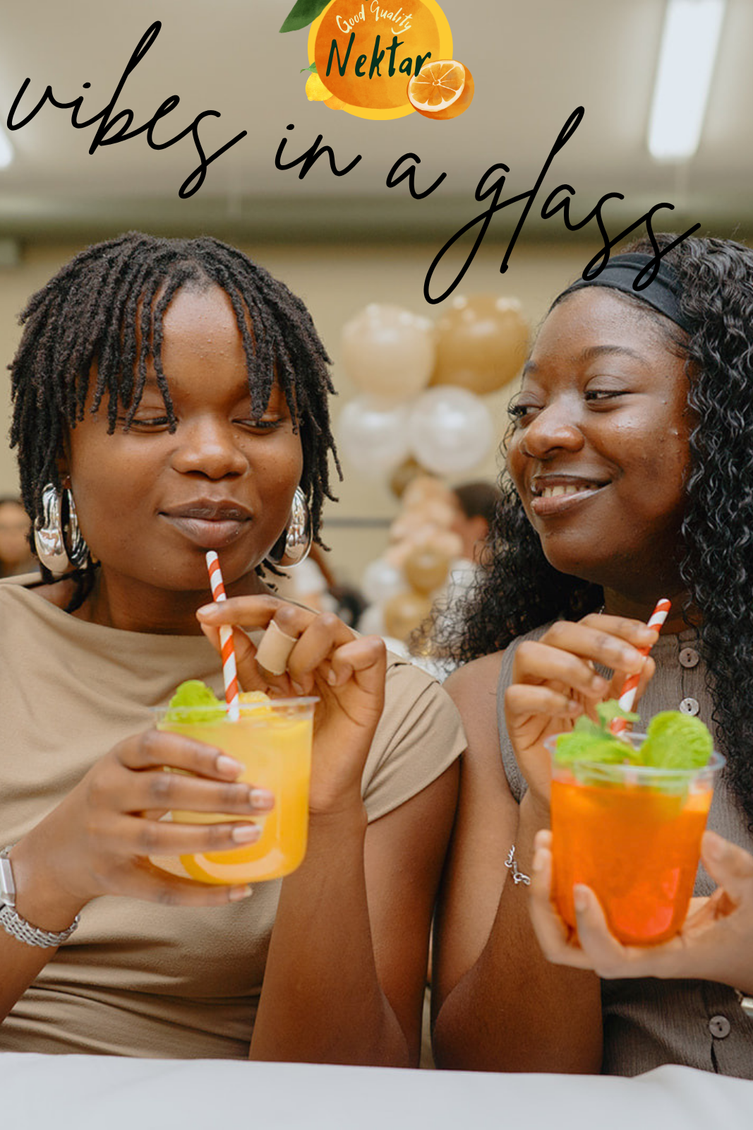 Two guests sipping yellow and orange mocktails through striped straws with balloons behind them